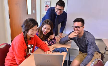 Group of students looking at a laptop