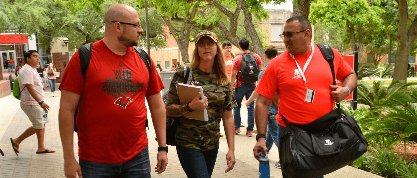 Three military veteran students walking outside on campus